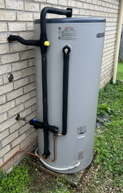 New Rheem hot water unit installed and plumbed on a brick wall